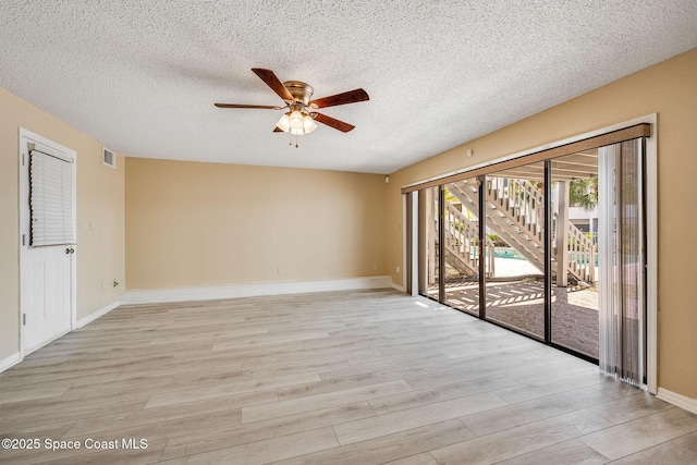 unfurnished room featuring light wood-type flooring, ceiling fan, and a textured ceiling