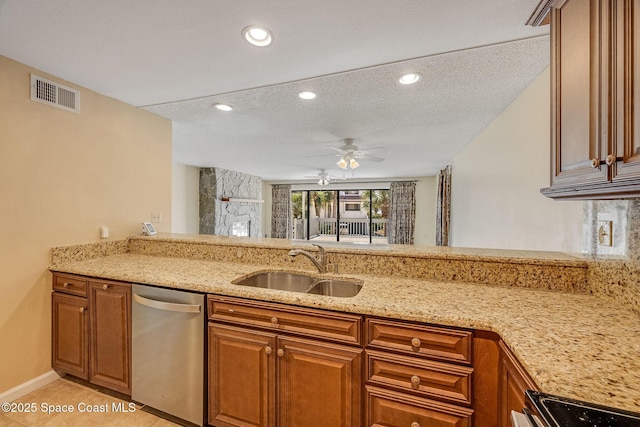 kitchen with a peninsula, a sink, visible vents, stainless steel dishwasher, and light stone countertops