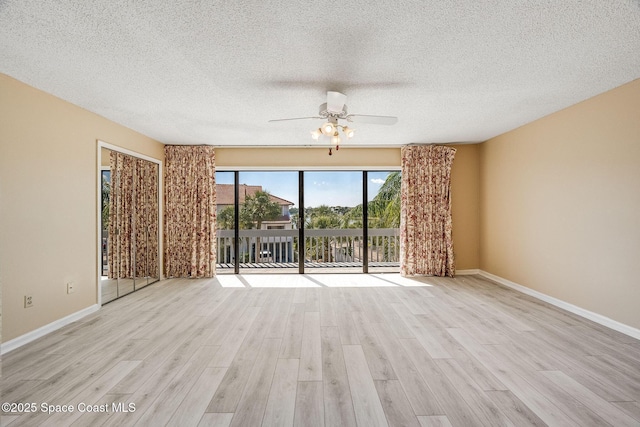 spare room with a textured ceiling, wood finished floors, a ceiling fan, and baseboards