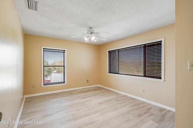 unfurnished room featuring visible vents, ceiling fan, and light wood-style flooring