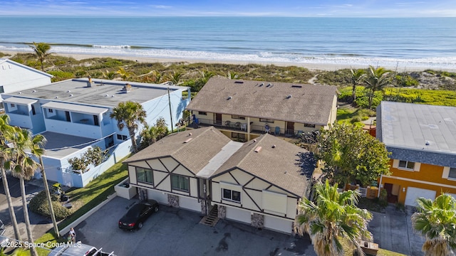 birds eye view of property with a water view and a beach view