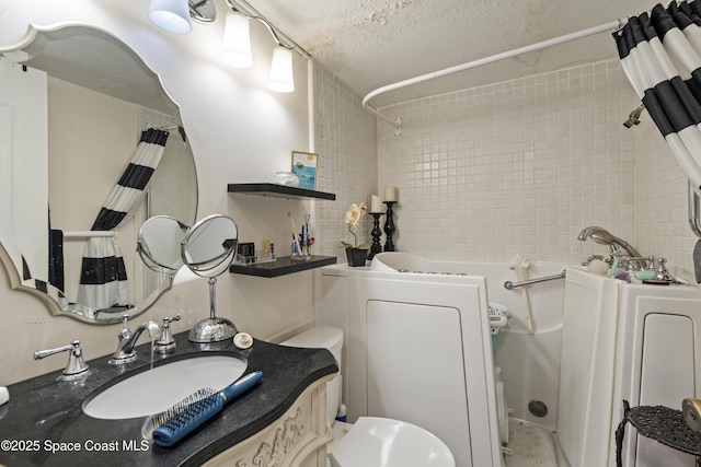 bathroom featuring a textured ceiling, toilet, vanity, washer / dryer, and shower / bathtub combination with curtain