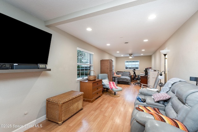 living room featuring light wood-type flooring, ceiling fan, baseboards, and recessed lighting