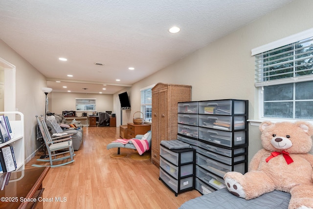 living room with recessed lighting, a textured ceiling, and wood finished floors