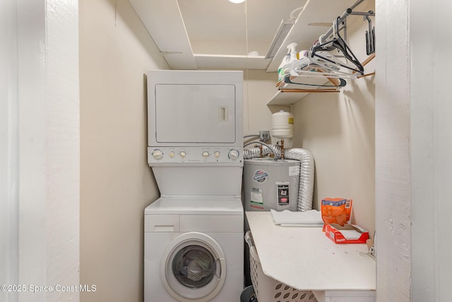 clothes washing area featuring laundry area, stacked washing maching and dryer, and electric water heater