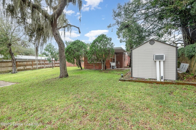 view of yard featuring fence private yard, a storage unit, and an outbuilding