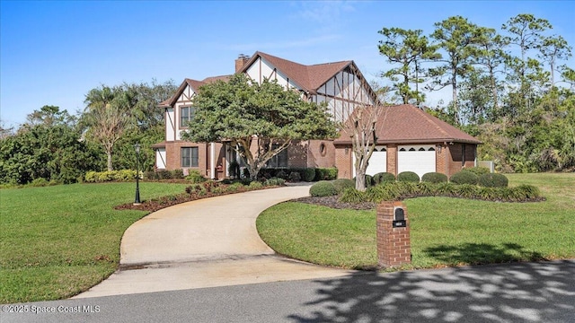 3794 Rambling Acres Dr, Titusville, FL 32796 - tudor house with brick siding, a chimney, concrete driveway, a front yard, and a garage