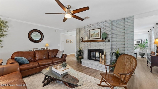 3794 Rambling Acres Dr, Titusville, FL 32796 - living room featuring a fireplace, visible vents, ornamental molding, a ceiling fan, and wood finished floors