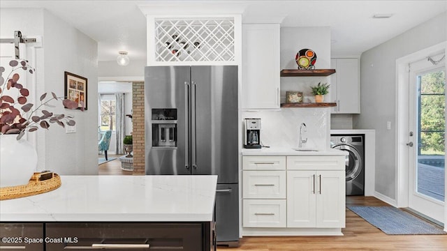 3794 Rambling Acres Dr, Titusville, FL 32796 - kitchen featuring washer / dryer, tasteful backsplash, white cabinetry, open shelves, and high end fridge