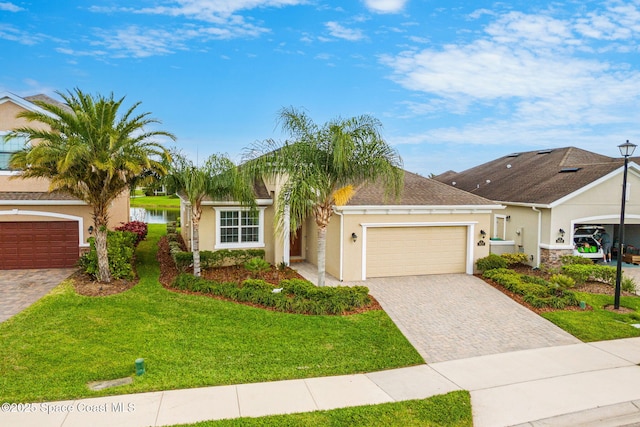 single story home with a garage, a front lawn, decorative driveway, and stucco siding