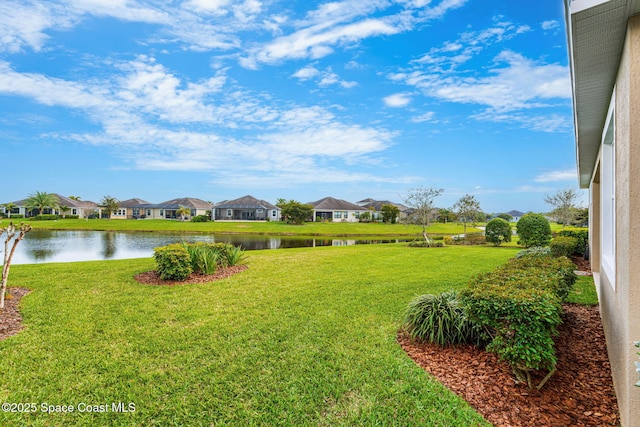 view of yard featuring a residential view and a water view