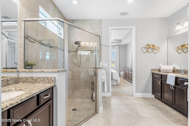 bathroom with a stall shower, two vanities, visible vents, and ensuite bathroom