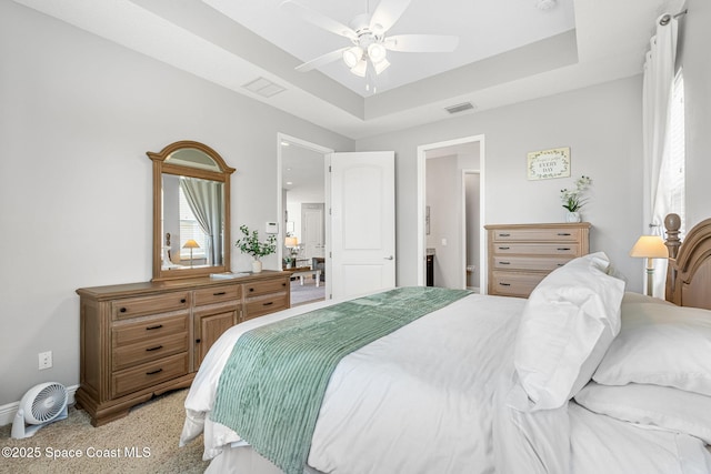 bedroom featuring ceiling fan, a tray ceiling, visible vents, and baseboards