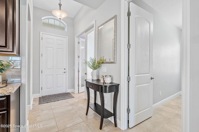 foyer entrance with baseboards and light tile patterned floors