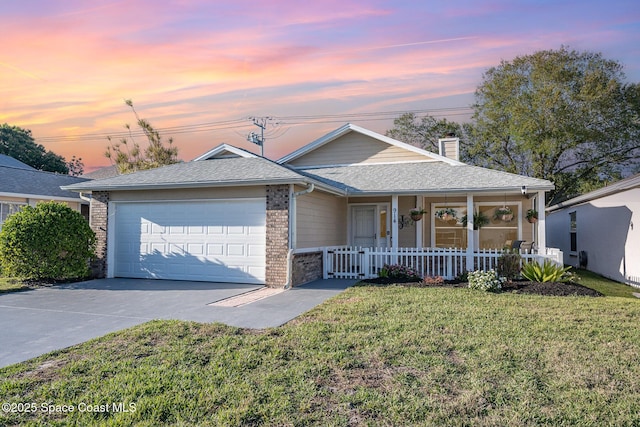 ranch-style home with a porch, a yard, an attached garage, concrete driveway, and brick siding