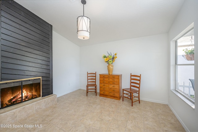 sitting room with a glass covered fireplace and baseboards