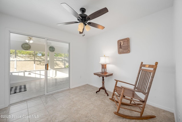 sitting room with light tile patterned floors, a ceiling fan, and baseboards