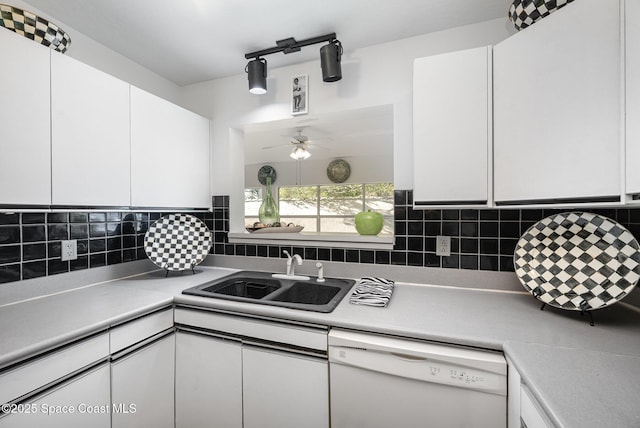 kitchen featuring a sink, backsplash, dishwasher, and white cabinets