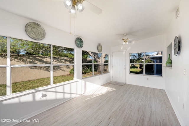 unfurnished sunroom featuring visible vents and a ceiling fan