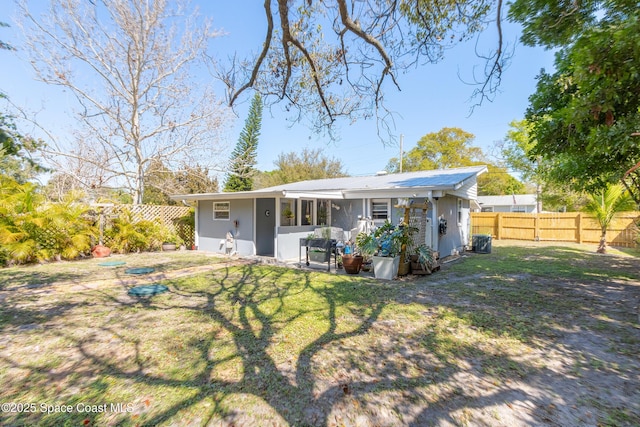 back of property with fence and a lawn