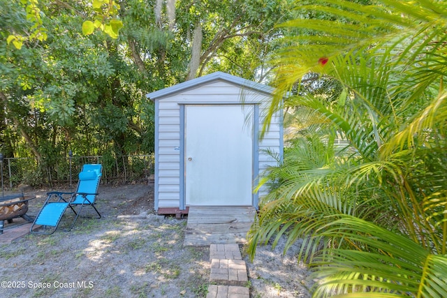 view of shed featuring fence