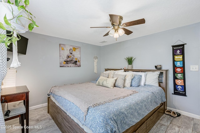 bedroom with ceiling fan, baseboards, and wood finished floors