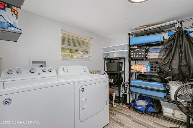 washroom featuring wood finish floors, laundry area, and washing machine and clothes dryer