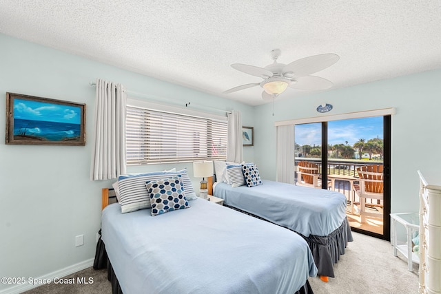 carpeted bedroom featuring access to outside, baseboards, ceiling fan, and a textured ceiling