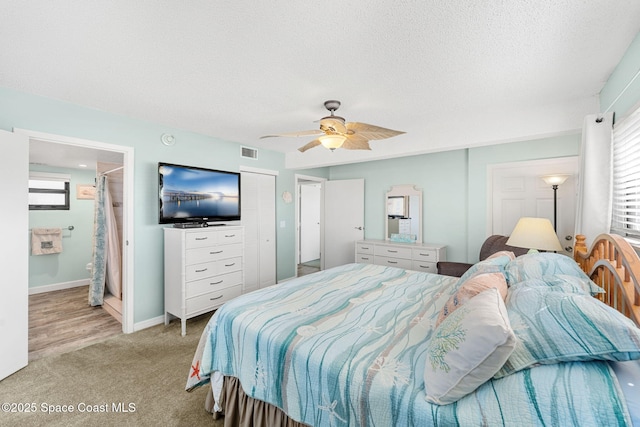 bedroom featuring light colored carpet, visible vents, a ceiling fan, a textured ceiling, and baseboards