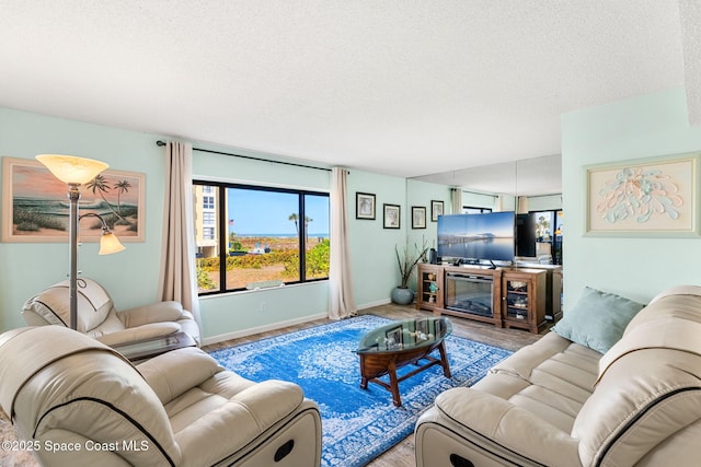 living area with a textured ceiling, baseboards, and wood finished floors