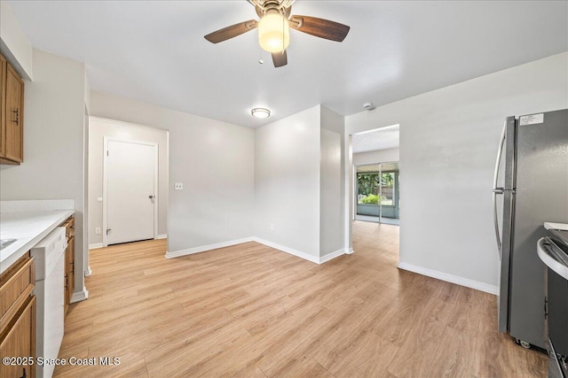 kitchen with baseboards, appliances with stainless steel finishes, brown cabinets, light countertops, and light wood-type flooring