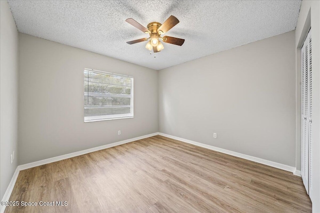 unfurnished bedroom featuring a textured ceiling, a closet, wood finished floors, and baseboards