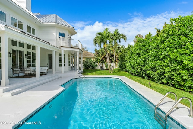 view of swimming pool featuring a patio, fence, an outdoor living space, a lawn, and a fenced in pool