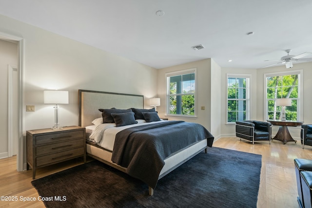 bedroom featuring visible vents, light wood-style flooring, and baseboards