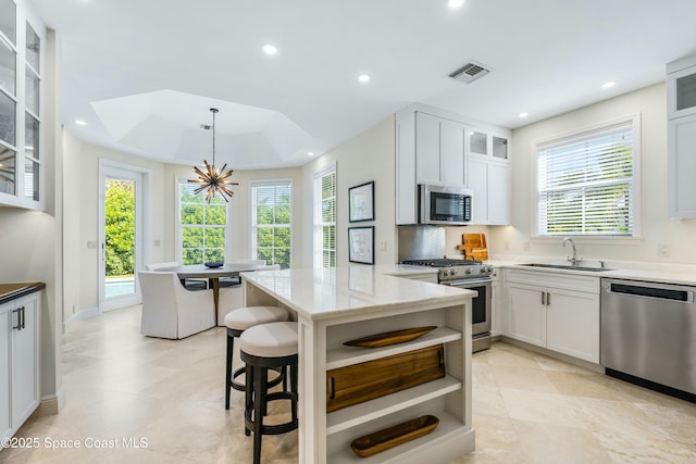 kitchen featuring open shelves, recessed lighting, visible vents, appliances with stainless steel finishes, and a sink