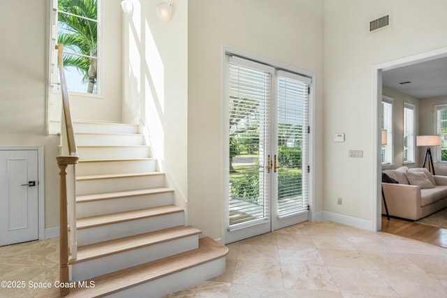 entryway with stairs, french doors, visible vents, and baseboards