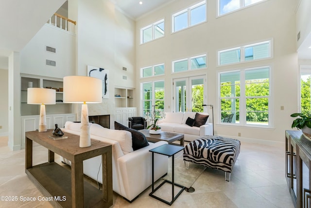 living area with light tile patterned floors, baseboards, built in features, visible vents, and a fireplace