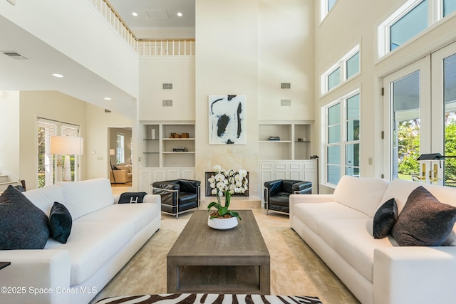 living area featuring visible vents, built in features, and a wealth of natural light