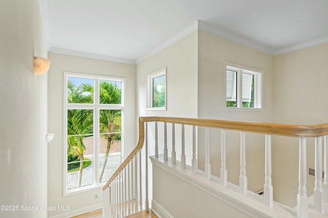 stairway featuring ornamental molding, a wealth of natural light, and baseboards