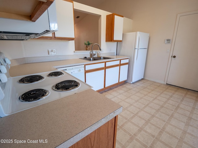 kitchen with white appliances, light floors, a sink, and light countertops