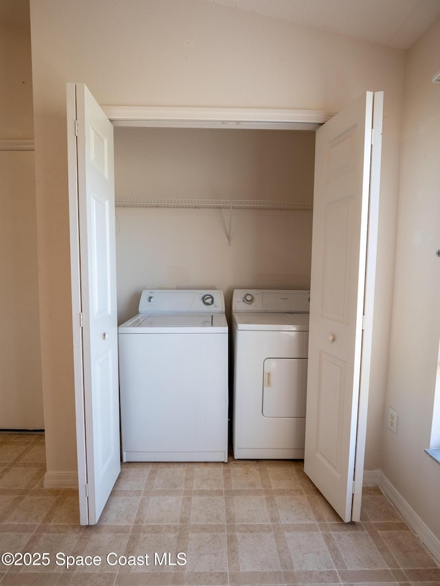 washroom featuring laundry area, separate washer and dryer, and baseboards