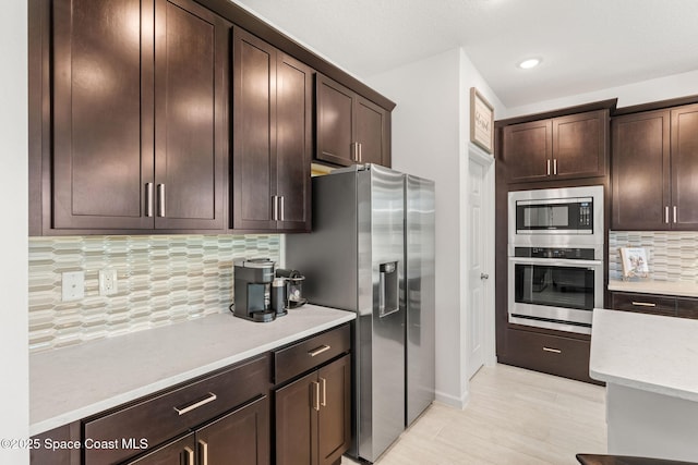 kitchen featuring dark brown cabinetry, appliances with stainless steel finishes, and light countertops