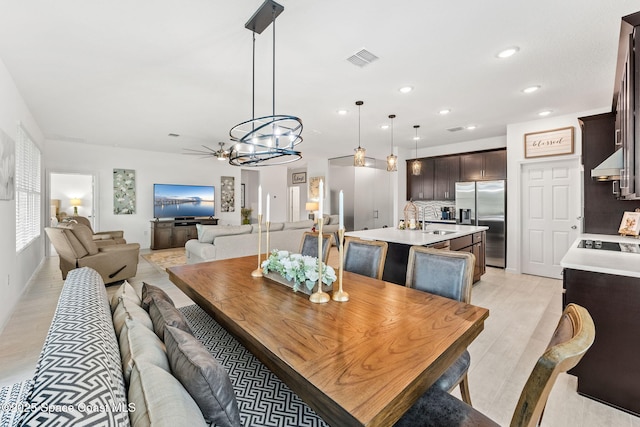 dining space with light wood-style flooring, visible vents, and recessed lighting