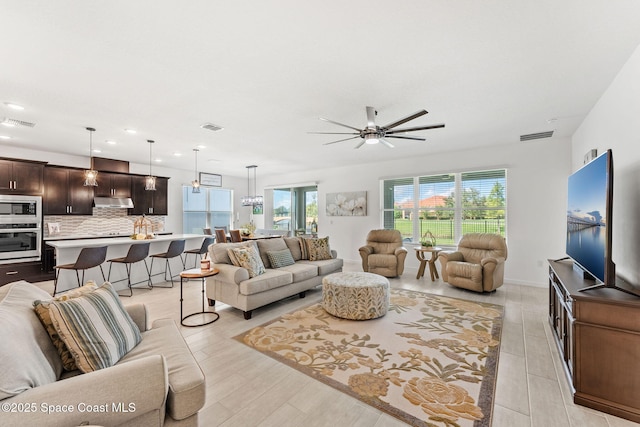 living area featuring light wood-type flooring, visible vents, and recessed lighting