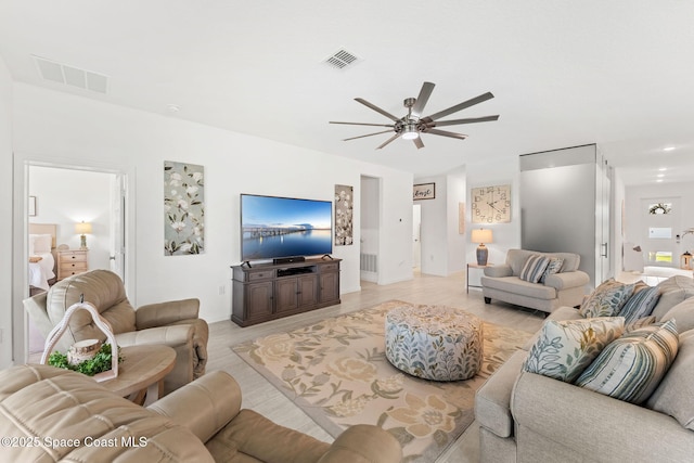 living area featuring a ceiling fan, visible vents, and light wood-style floors