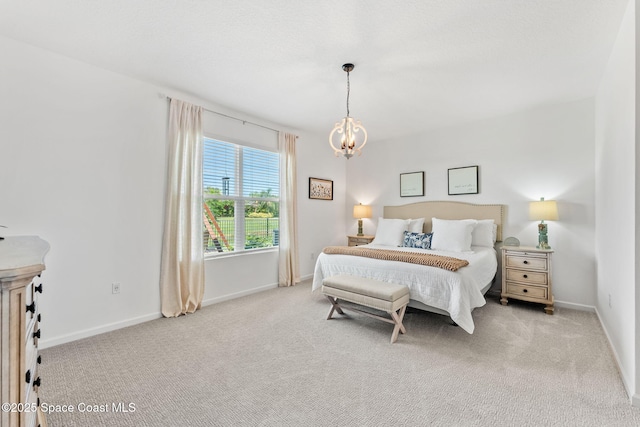 bedroom with an inviting chandelier, baseboards, and carpet flooring