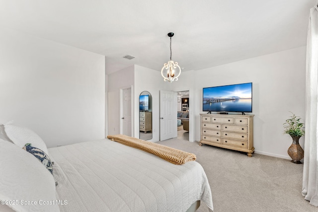 carpeted bedroom featuring baseboards, visible vents, and a notable chandelier