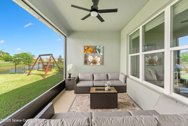 sunroom / solarium with ceiling fan and a water view