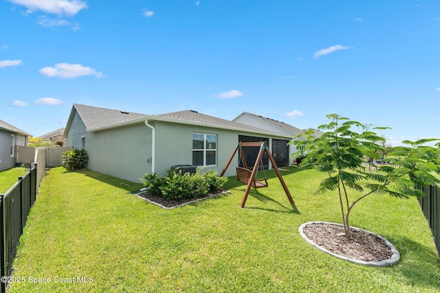 rear view of property featuring a yard, a fenced backyard, and stucco siding