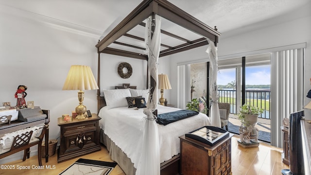 bedroom featuring access to exterior and light wood finished floors